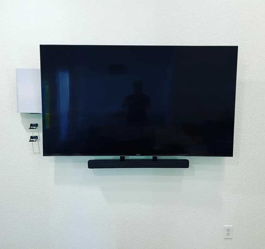 Soundbar mounted below a wall-mounted TV